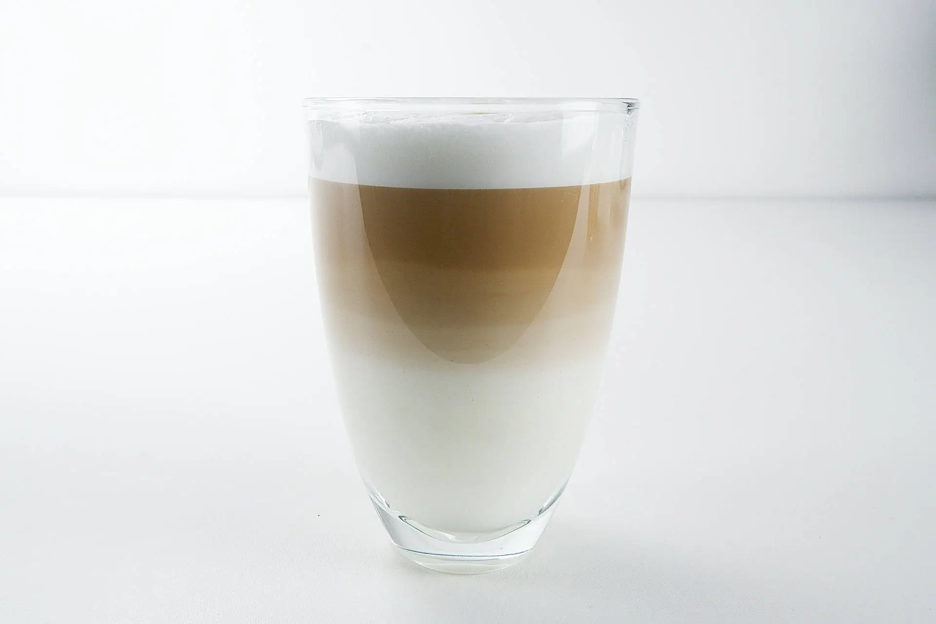 Latte macchiato Zde je vysoká sklenice s tříbarevným latte macchiato.