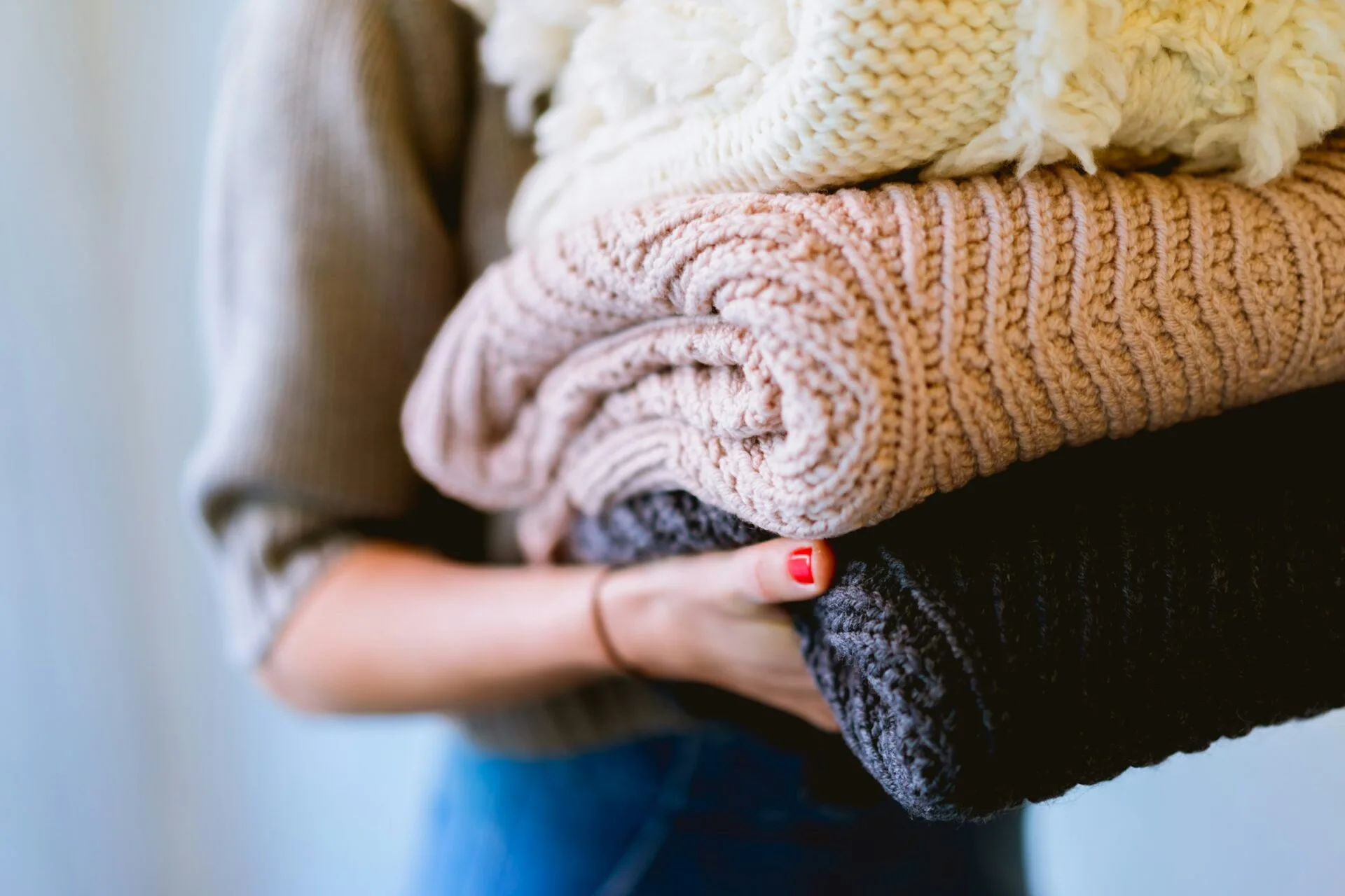Za úspěšnou instalaci pračky vám bude odměnou čisté prádlo (foto: Unsplash, Dan Gold) Obrázek zobrazuje ženu nesoucí složené prádlo