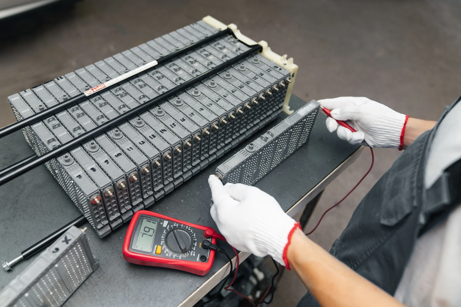 Technik měří multimetrem modul trakční baterie elektromobilu