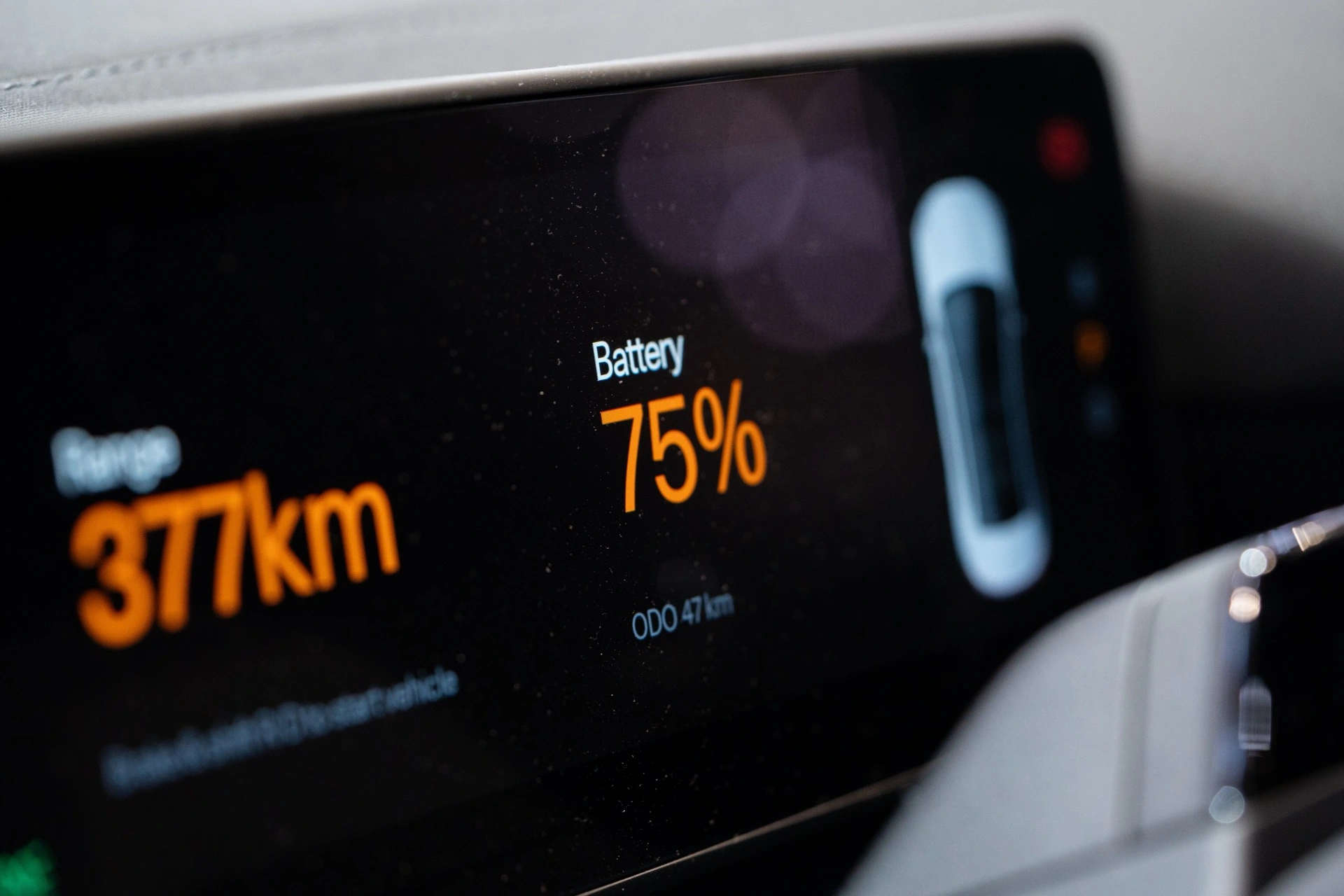 Displej elektromobilu s údajem o dojezdu a stavem počítadla kilometrů
