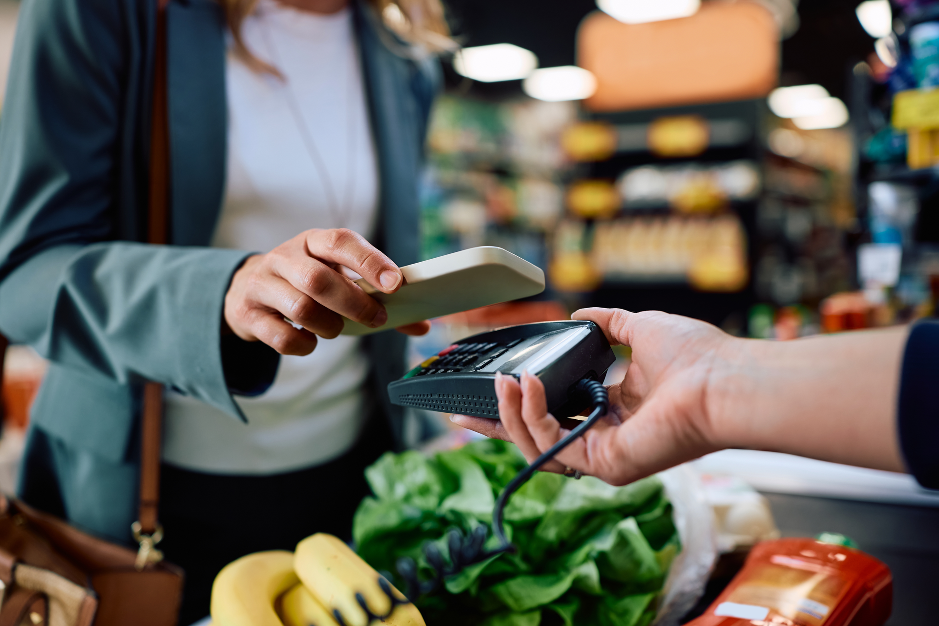 Zákazník platí mobilem u pokladny supermarketu
