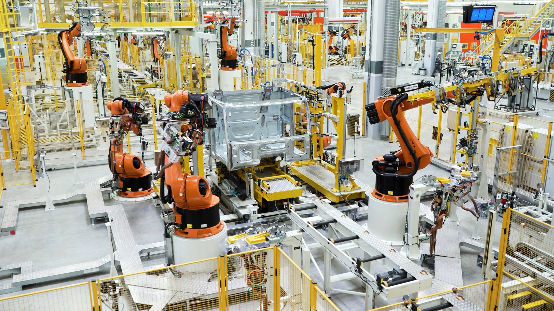 Roboty svařují karoserii na výrobní lince automobilky