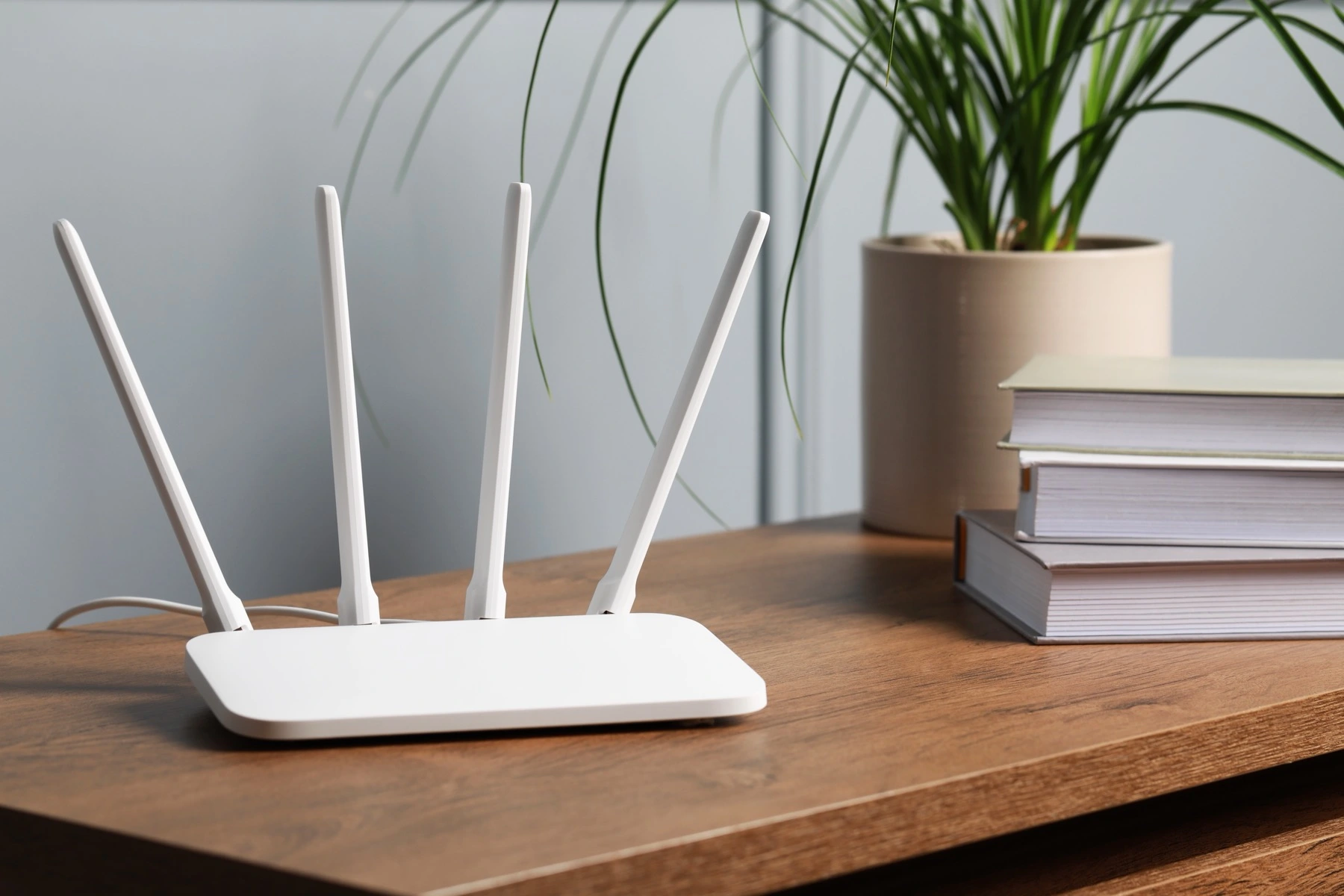 Bílý Wi-Fi router s anténami na stole v obývacím pokoji