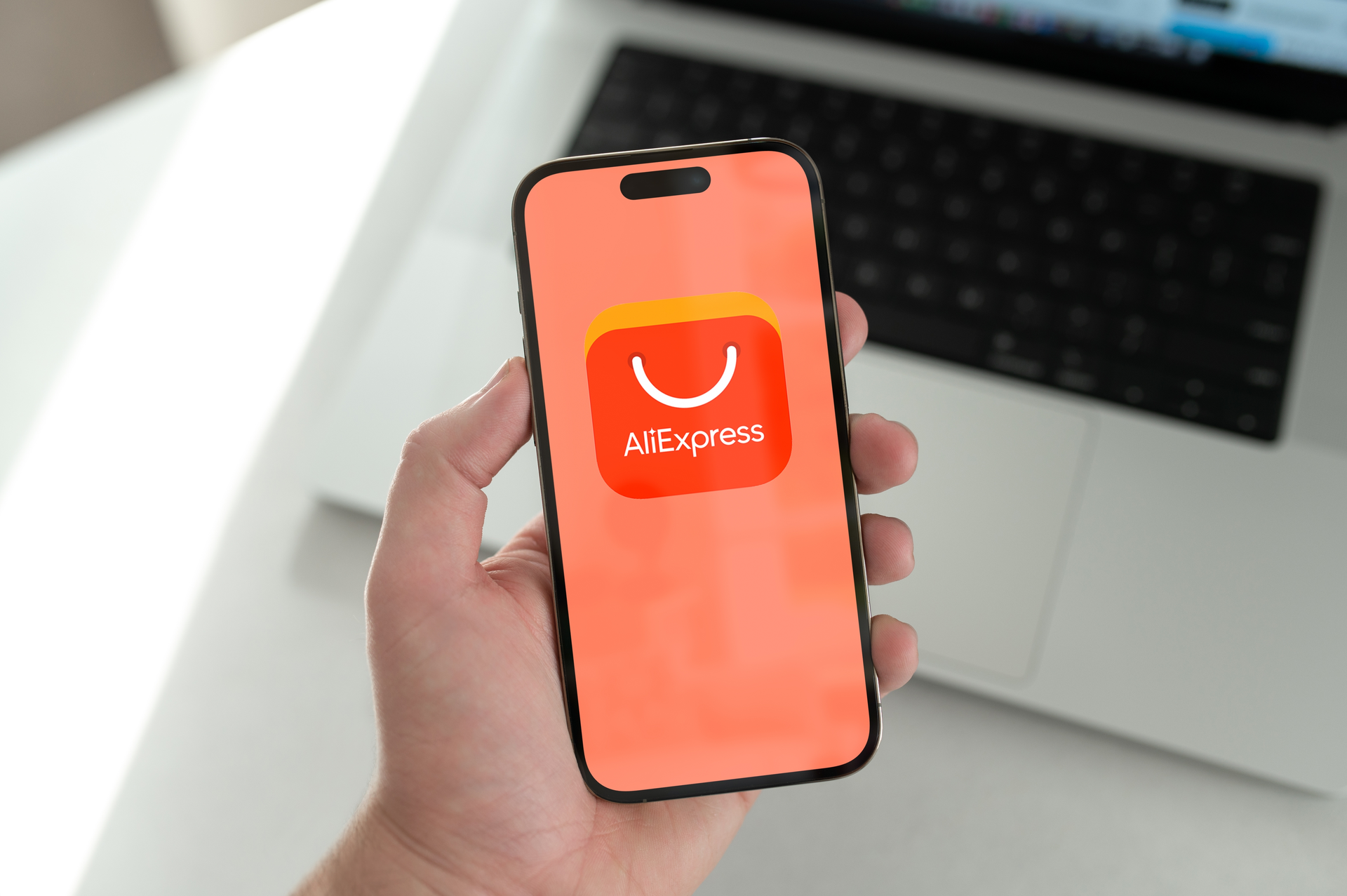 Ruka s telefonem s otevřenou aplikací čínského tržiště AliExpress