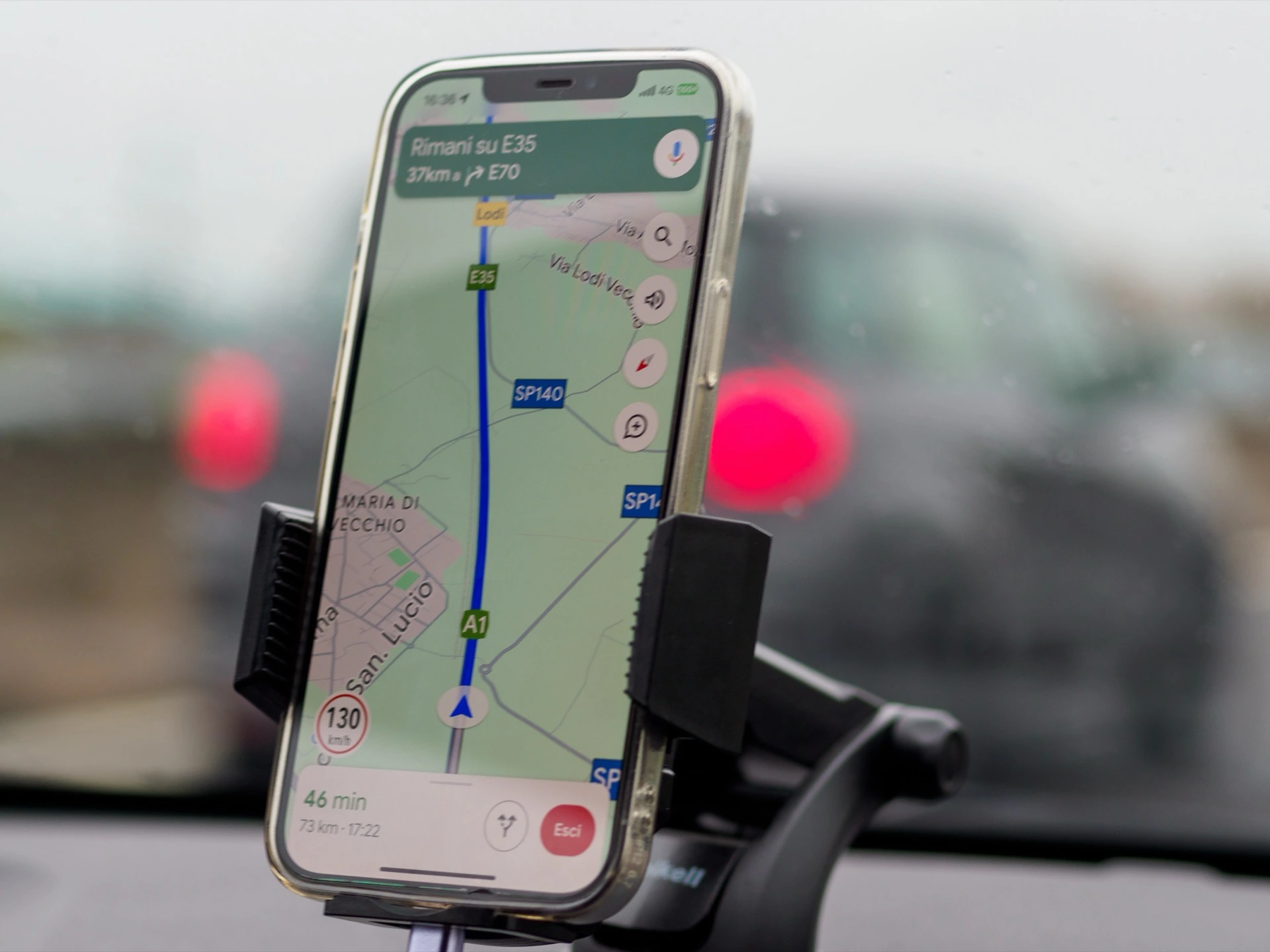 Telefon v držáku v autě s otevřenými Google Mapami
