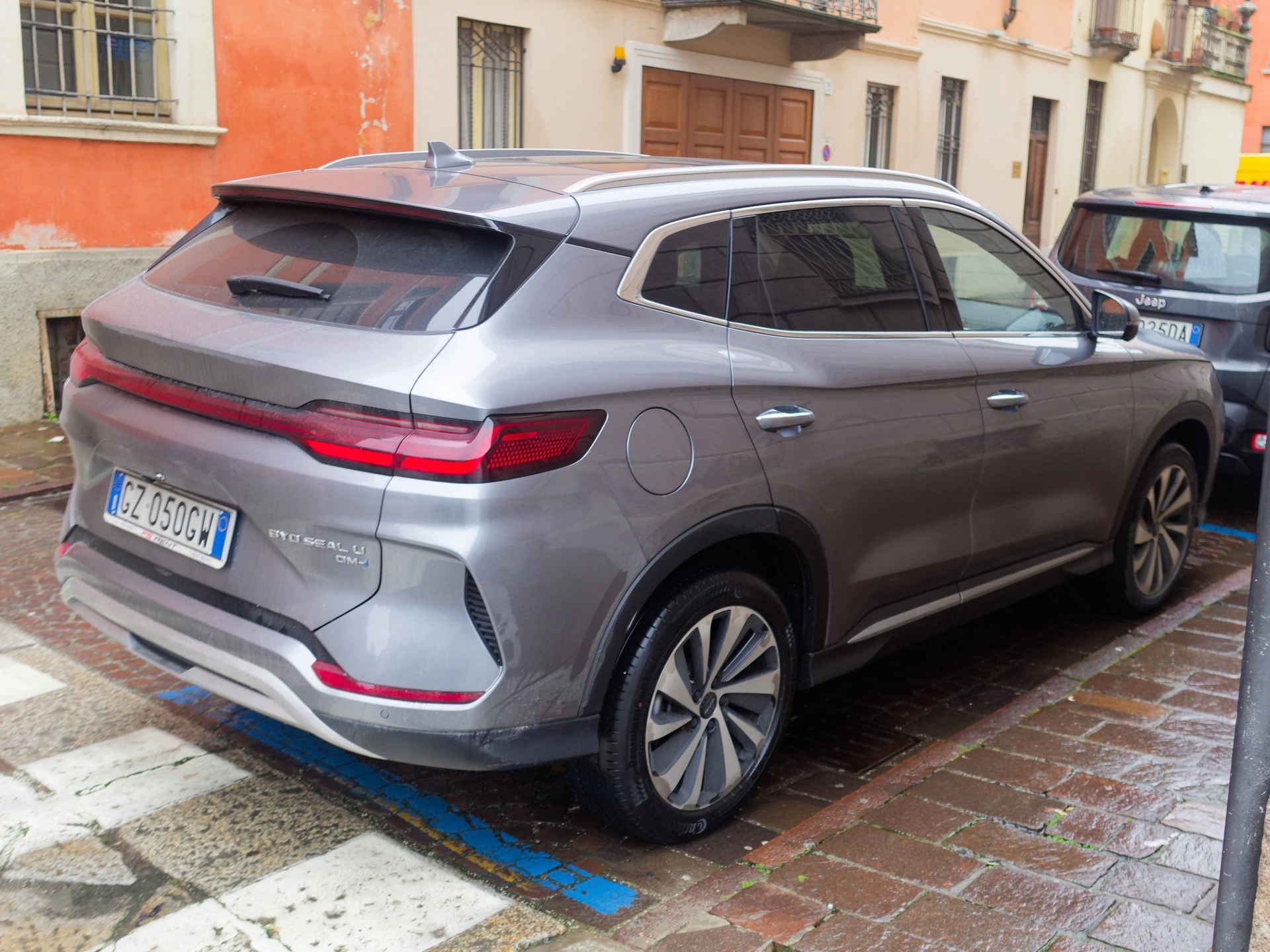 Šedý BYD Seal U DM-i zaparkovaný na dlážděné ulici