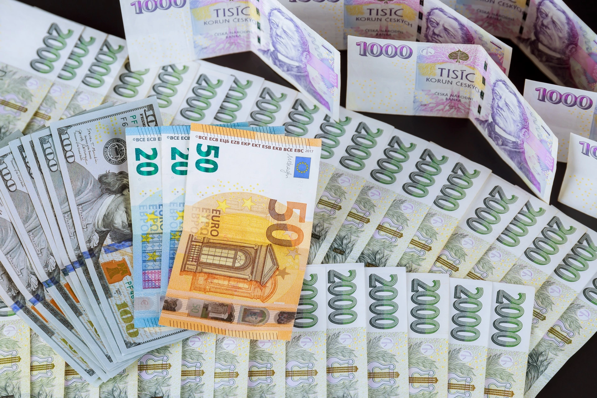 České koruny a eurobankovky pohromadě na stole.