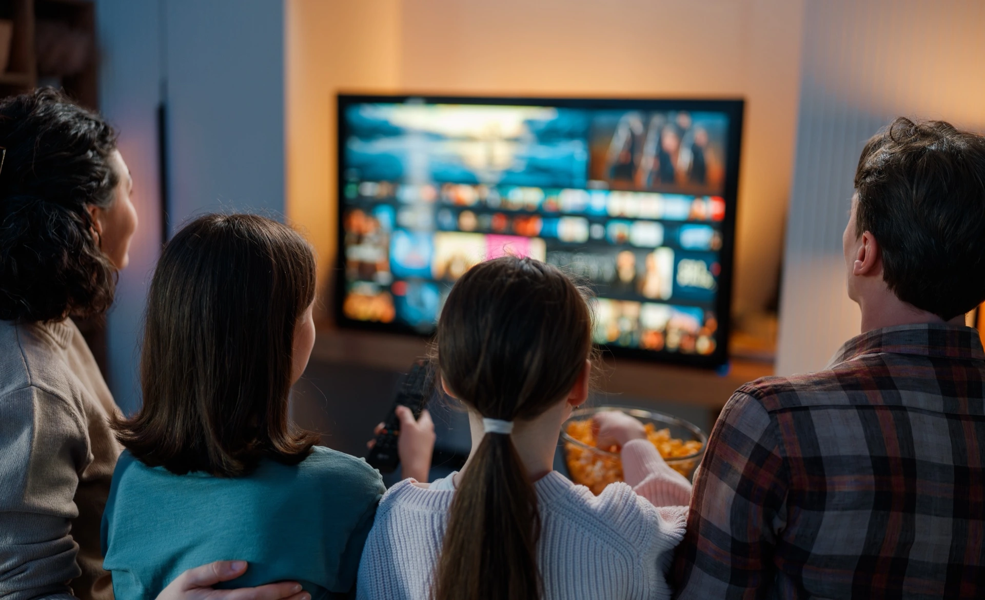 Rodina na gauči vybírá pořad z nabídky videotéky na televizi